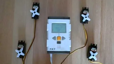 Four servos wired to the LEGO NXT brick on a table