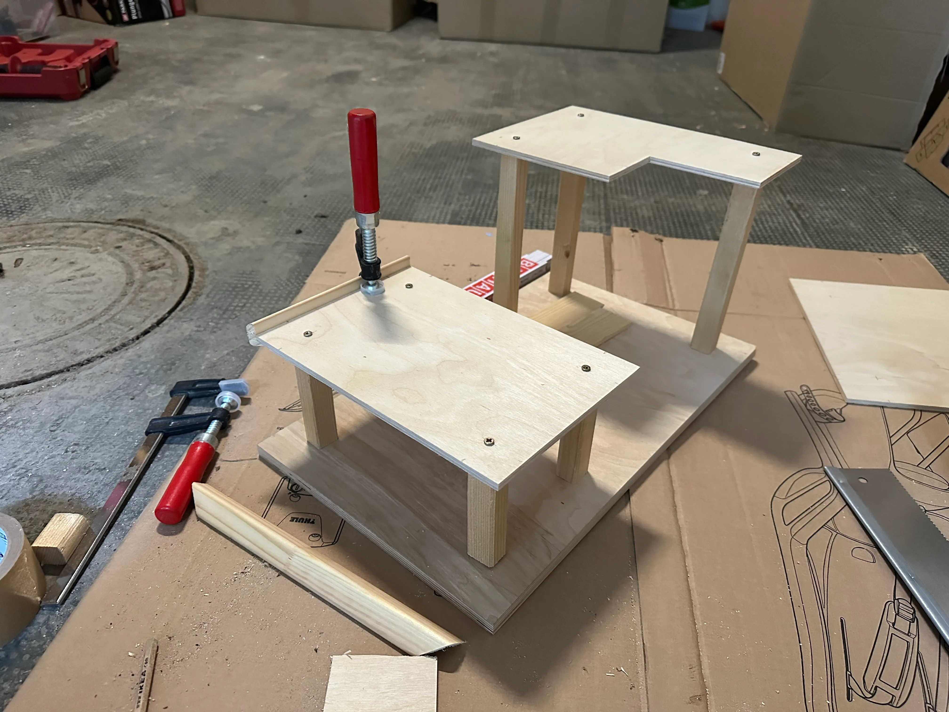 The garage mid-assembly in the workshop, decks clamped while the glue dries