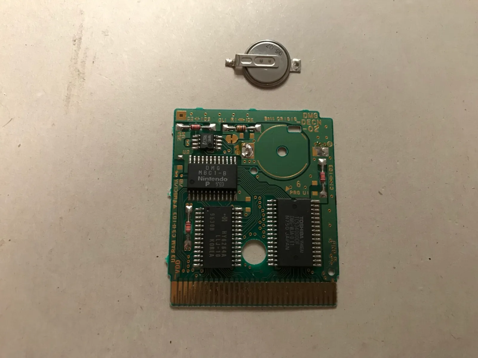 The cartridge board with the old tabbed battery desoldered
