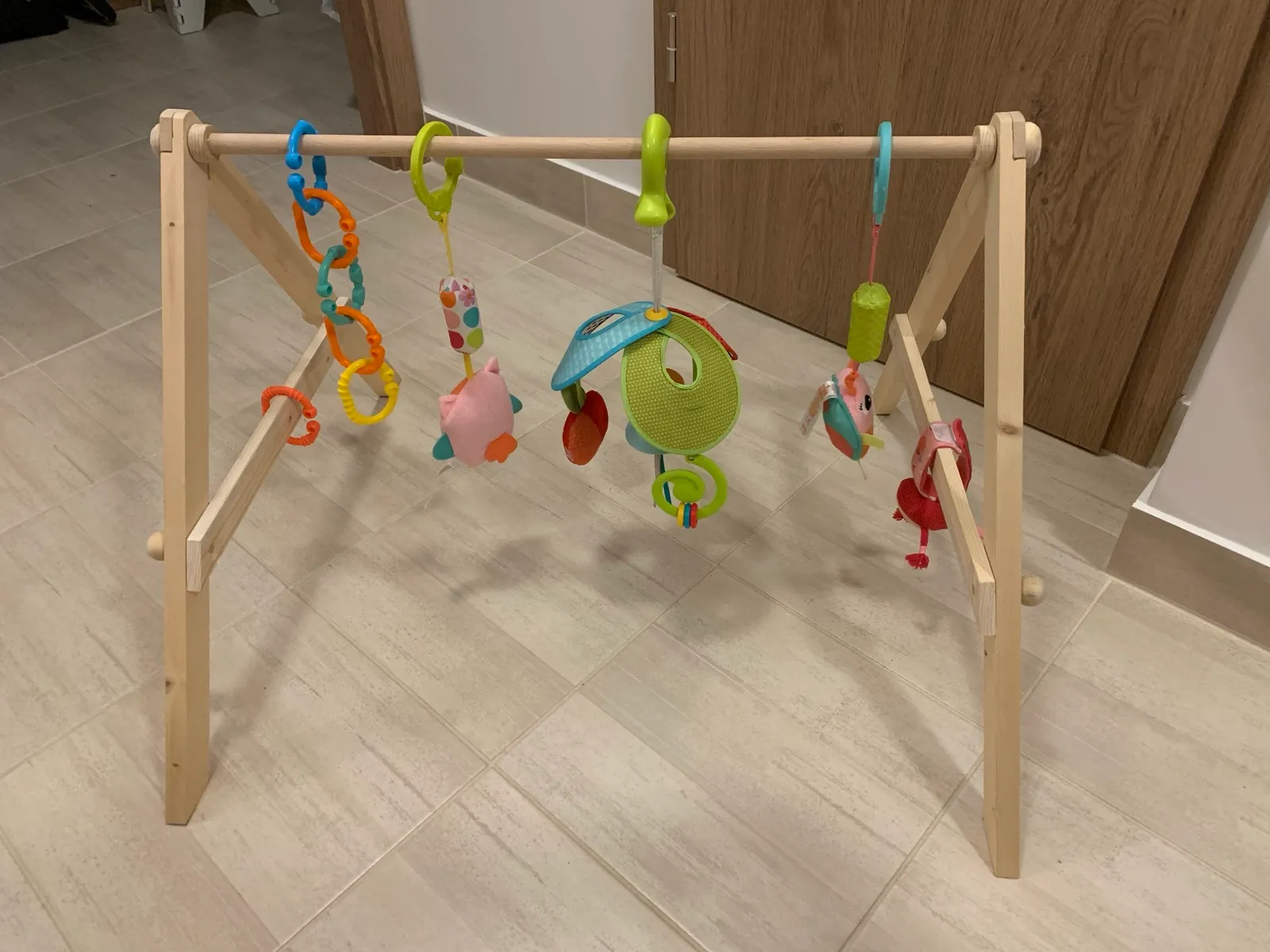 The finished baby gym with toys hanging from the crossbar