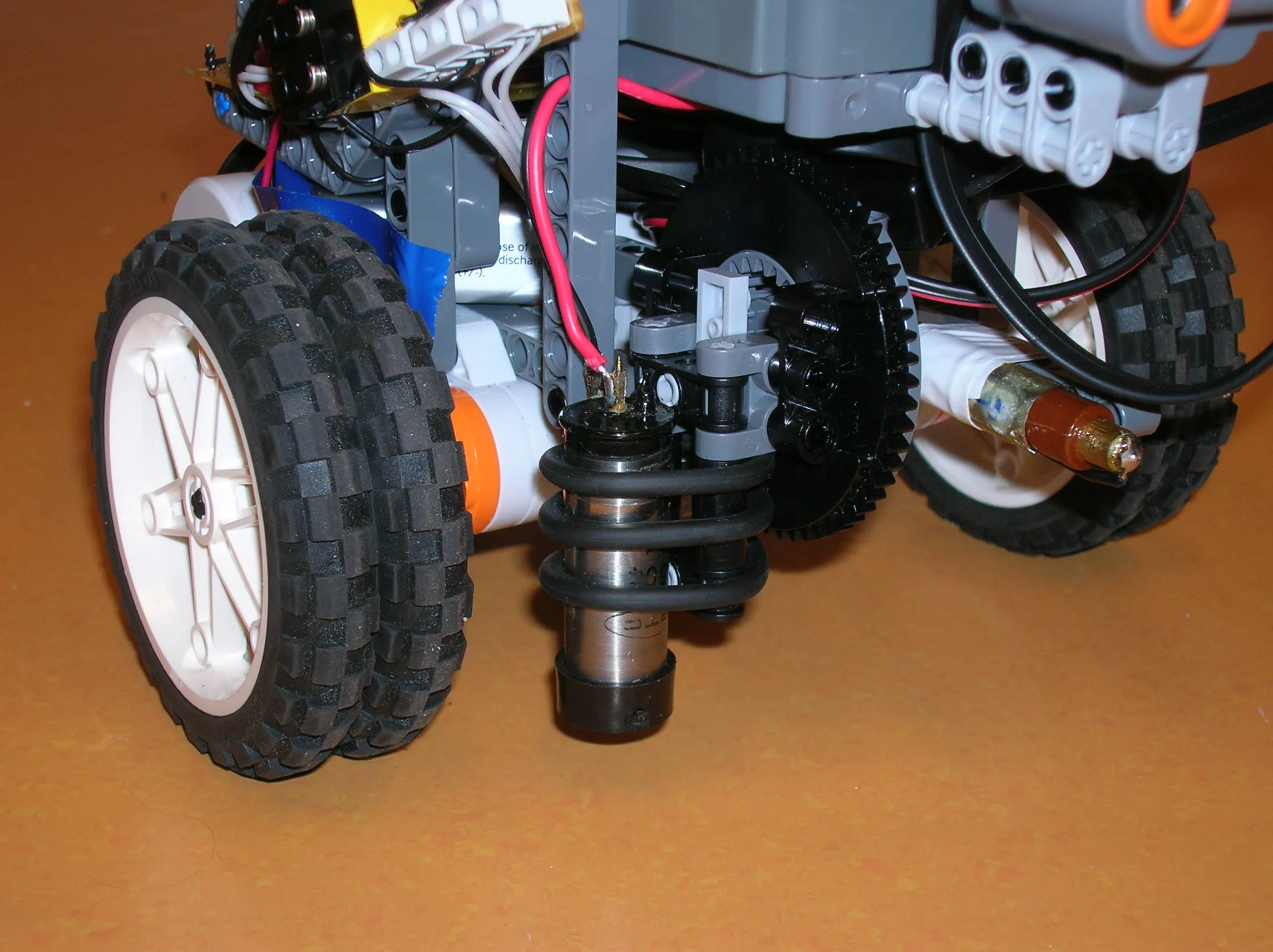 The Geiger-Müller tube turned to point at the floor for mapping, held with rubber rings on the rotating gear
