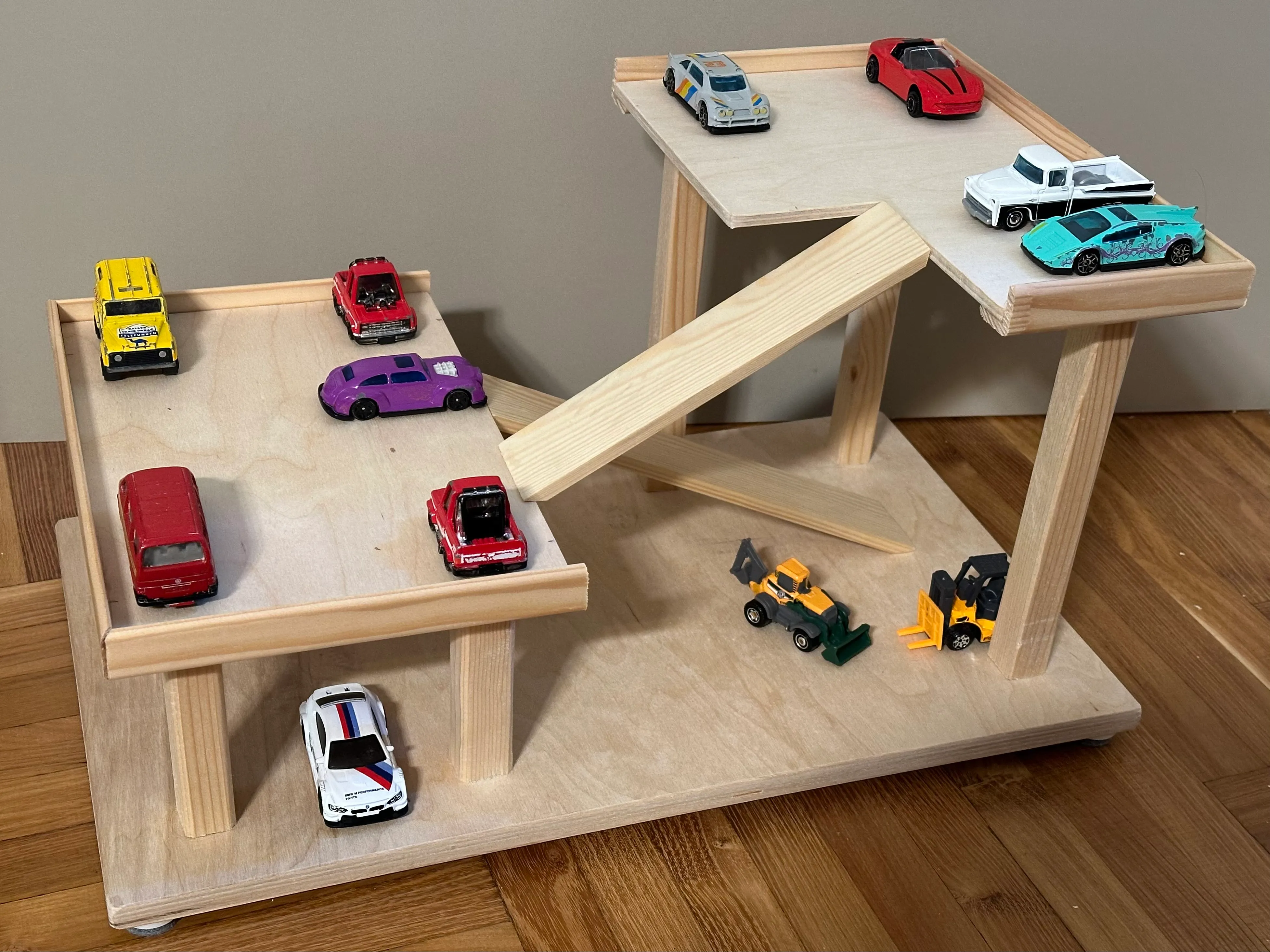 Multistorey wooden toy parking garage filled with toy cars of various sizes